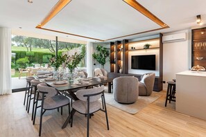 A modern dining area with a large table set for six, surrounded by comfortable seating. - Luxury Golf Townhouse in Aloha with Pool & Garden (Marbella)