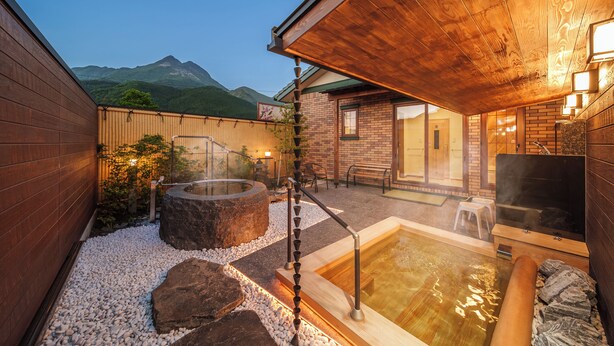 Un espace bien-être avec des bains à remous, une terrasse en bois et une vue sur la montagne.