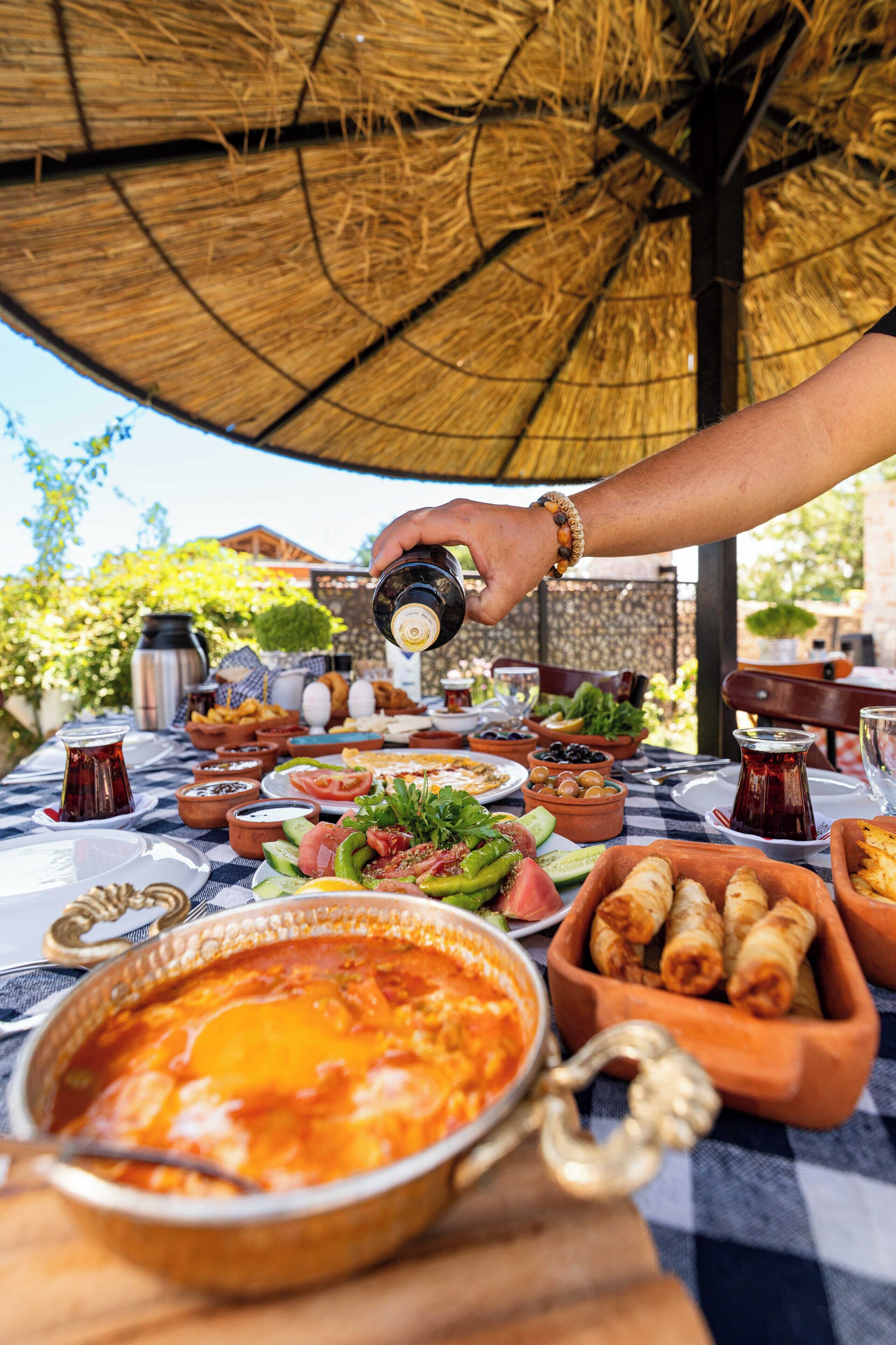 A table set with various dishes, including a bowl of soup, a plate of salad, and a bowl of olives.