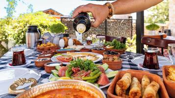 A table set with various dishes, including a bowl of soup, a plate of salad, and a bowl of olives.