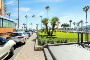 Ein Hotel mit Parkplatz, Palmen und blauem Himmel.