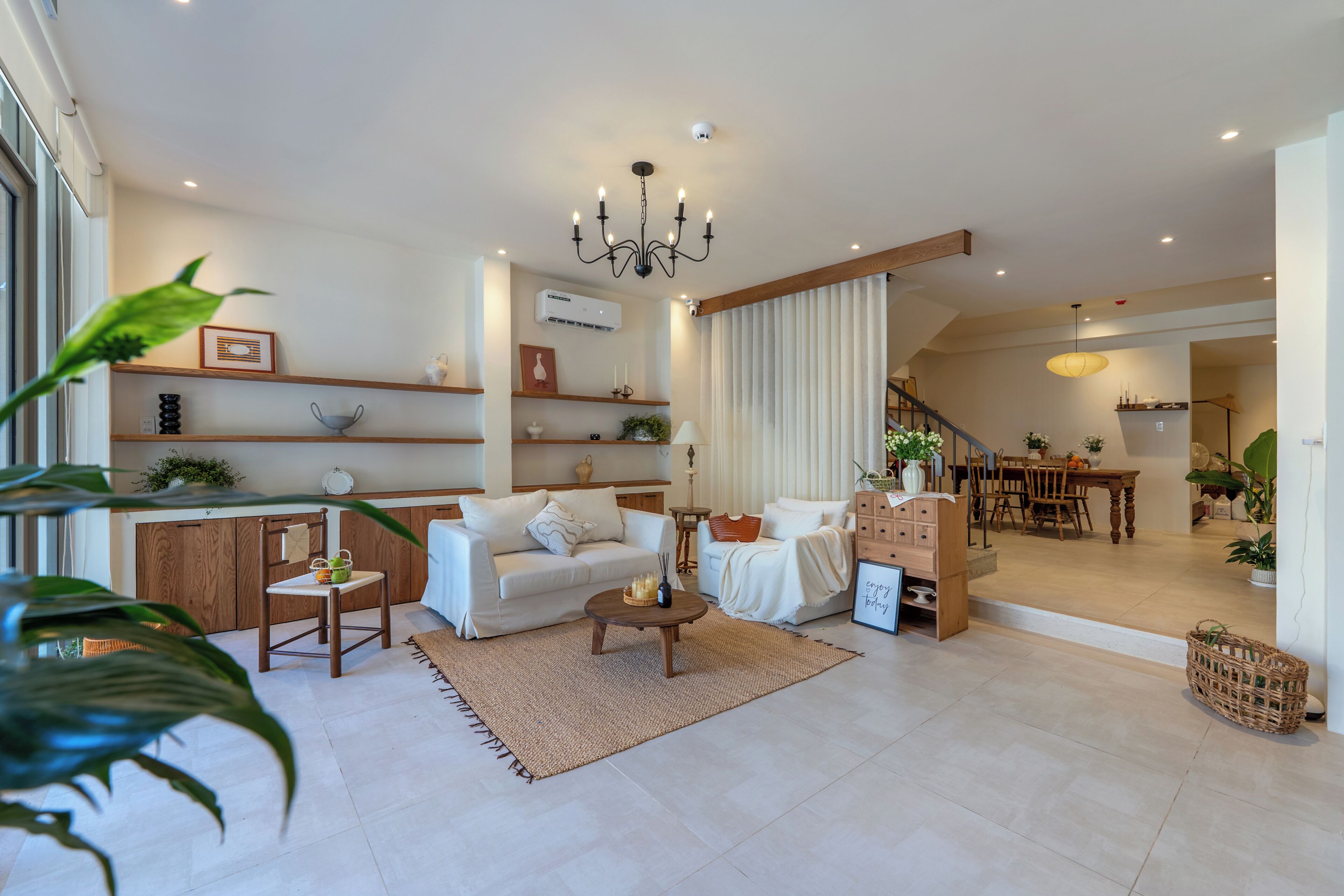 Uma sala moderna com sofá, mesa de centro e área de jantar com mesa e cadeiras.