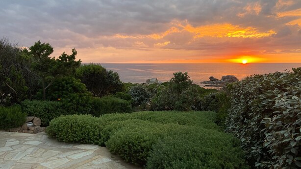 Un sendero de piedra que conduce a un mirador con vistas al atardecer.