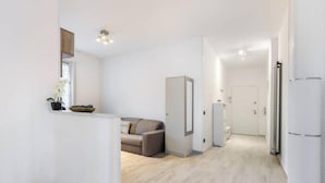 Un intérieur moderne et minimaliste, avec un canapé, un meuble et un réfrigérateur.