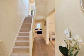A staircase leading to a room with a bed, a window, and a plant. - The Arch & Lightwell - Chelsea (London)