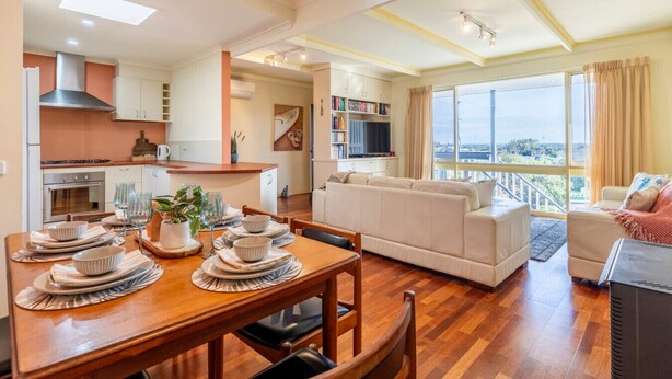 Un appartement moderne comprenant un coin repas, une cuisine, un salon et un balcon avec vue sur la ville.