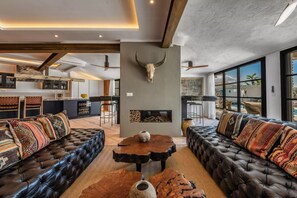 A modern living room with a large sofa, a coffee table, and a fireplace. - Bohemian villa with pool near Canillas (Canillas de Aceituno)