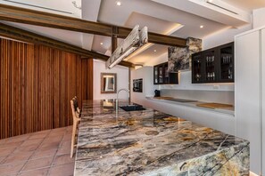 A modern kitchen with marble countertops, wooden accents, and built-in cabinetry. - Bohemian villa with pool near Canillas (Canillas de Aceituno)