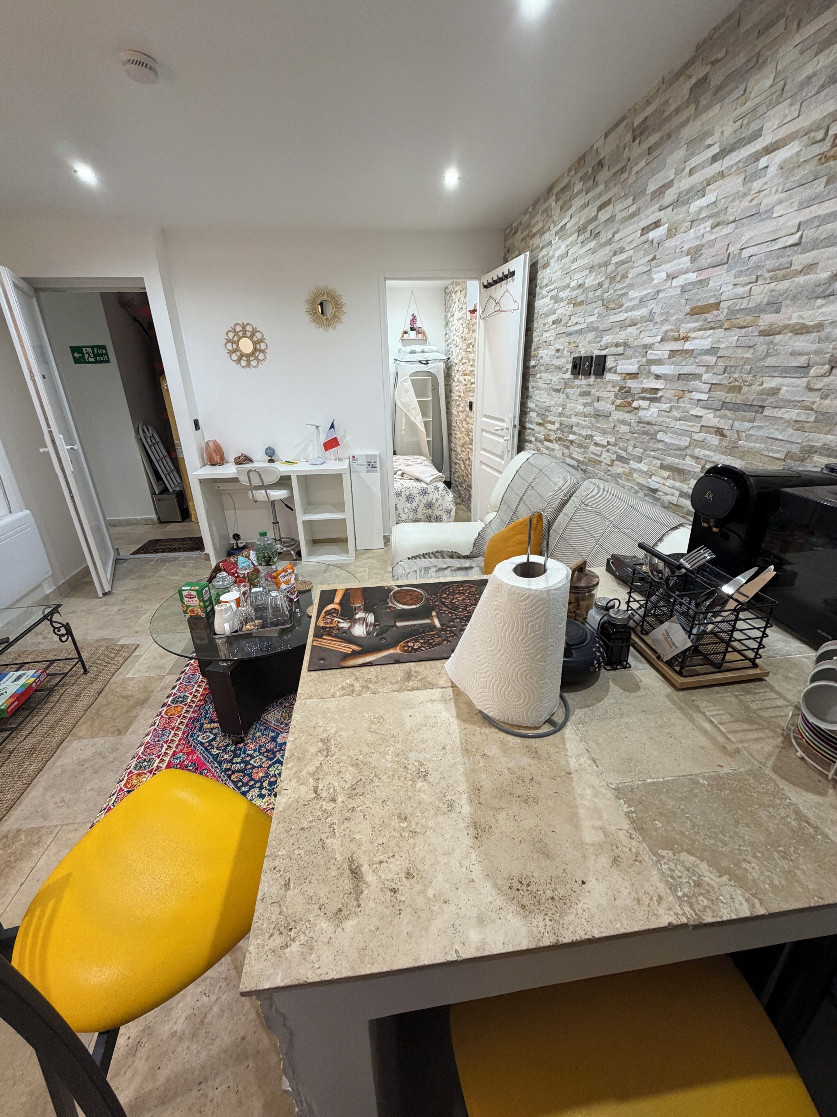 Un espacio habitable compacto con kitchenette, zona de comedor y cama.