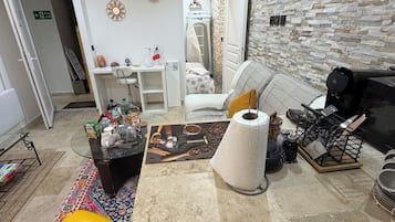 Un espacio habitable compacto con kitchenette, zona de comedor y cama.
