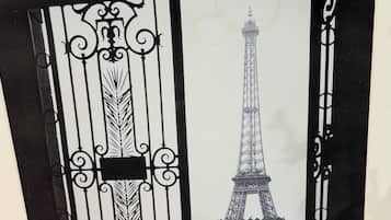 A black and white photo of the Eiffel Tower through a decorative iron gate.