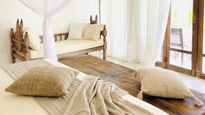 A room with a bed, a wooden bench, and a sofa.