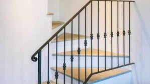 Una escalera con barandilla de metal negro y escalones de madera.
