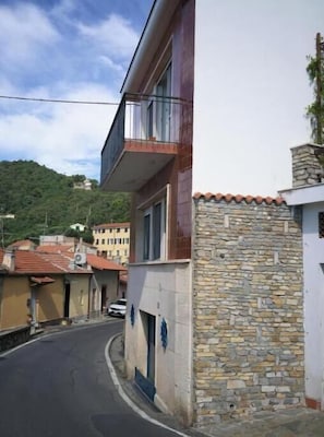 Een smalle straat met een gebouw met een stenen muur en een balkon.