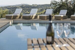 Ein Poolbereich mit Liegestühlen und einer Flasche.