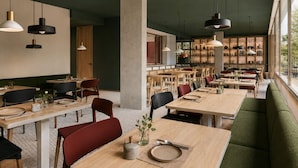 A spacious restaurant with high ceilings, pendant lighting, and a view through large windows. - Hotel Gat Massarelos 3  (Porto)