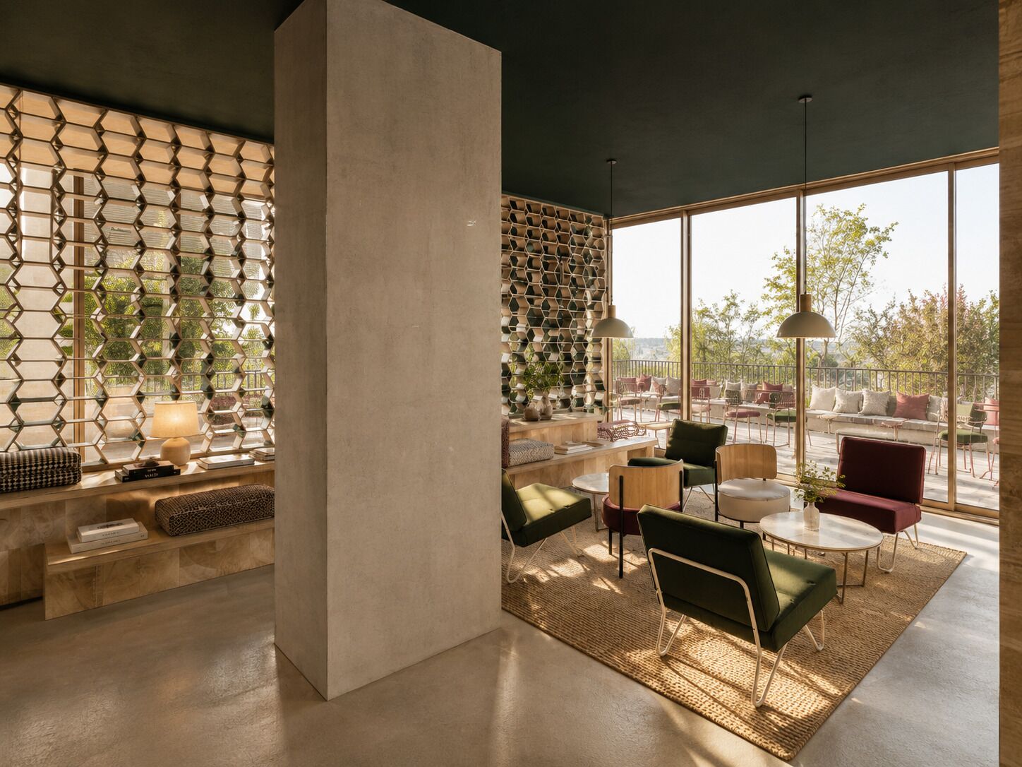 Un intérieur moderne avec une colonne en béton, des panneaux muraux hexagonaux et un espace détente avec des tables et des chaises.