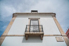Ein Gebäude mit Balkon, Fenster und einer Gedenktafel.
