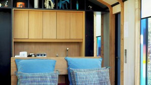 A bedroom with a wooden ceiling, a bed with blue bedding, and a shelf with various items. - Designer cabin with shared pool in Bras (Bras)