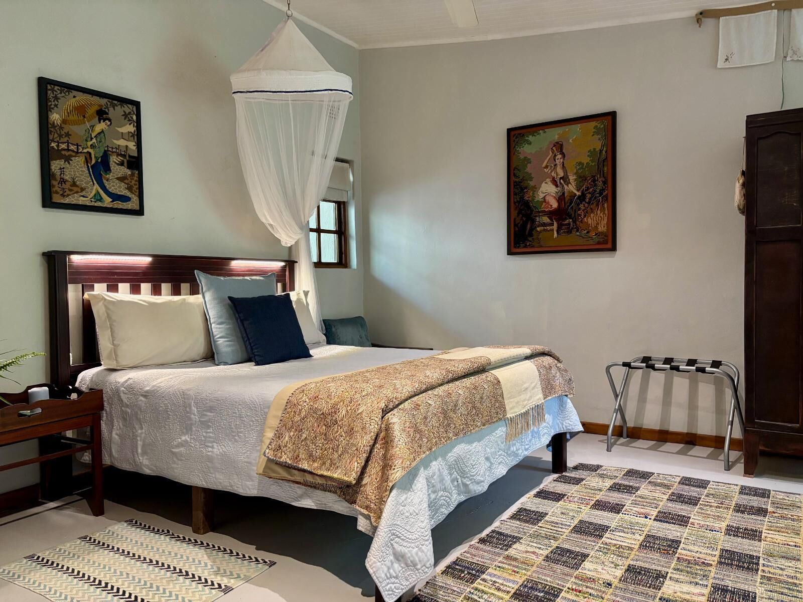 Une chambre à coucher bien rangée, avec un lit, une table de chevet et une petite table d’appoint.