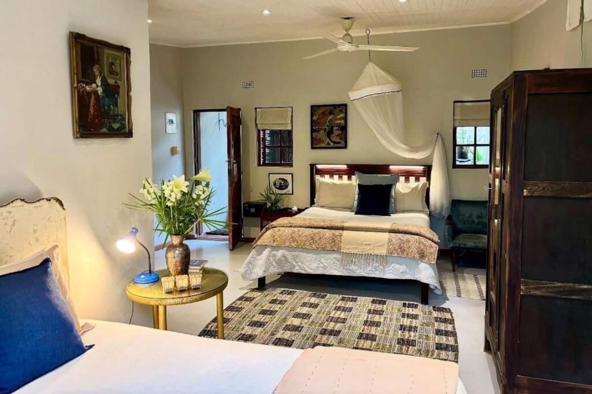 Un dormitorio con cama, mesita de noche, lámpara y ventilador de techo.