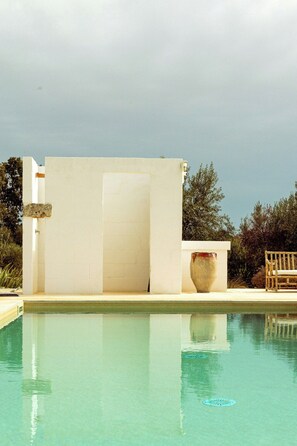 A swimming pool with a white wall and a large vase. - Farmhouse with pool in olive grove near Ostuni (Ostuni)