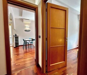Una puerta de madera que da a un comedor con una mesa y sillas.