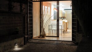 A doorway leading into a room with a dining area, a vase with branches, and a brick wall. - Villa with pool at Lake Bracciano (Bracciano)