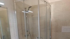 A modern bathroom with a glass shower enclosure, a white sink, and a toilet. - osteria il becco fine affittacamere (Cumignano sul Naviglio)