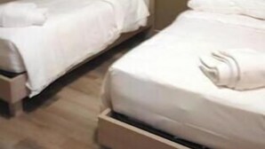 A hotel room with two beds, wooden flooring, and a neutral color scheme. - osteria il becco fine affittacamere (Cumignano sul Naviglio)