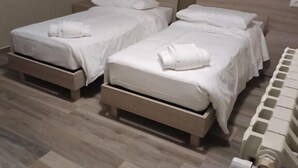 Two single beds with wooden frames, white bedding, and towels. - osteria il becco fine affittacamere (Cumignano sul Naviglio)