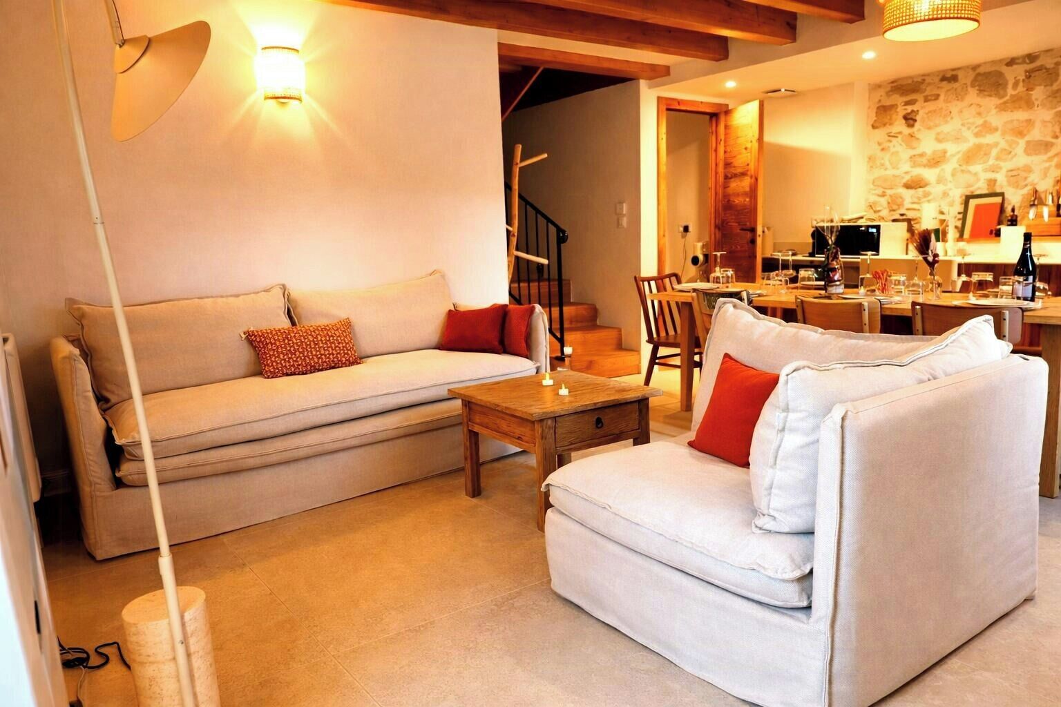 A living room with a sofa, a coffee table, and a dining area with a table and chairs.
