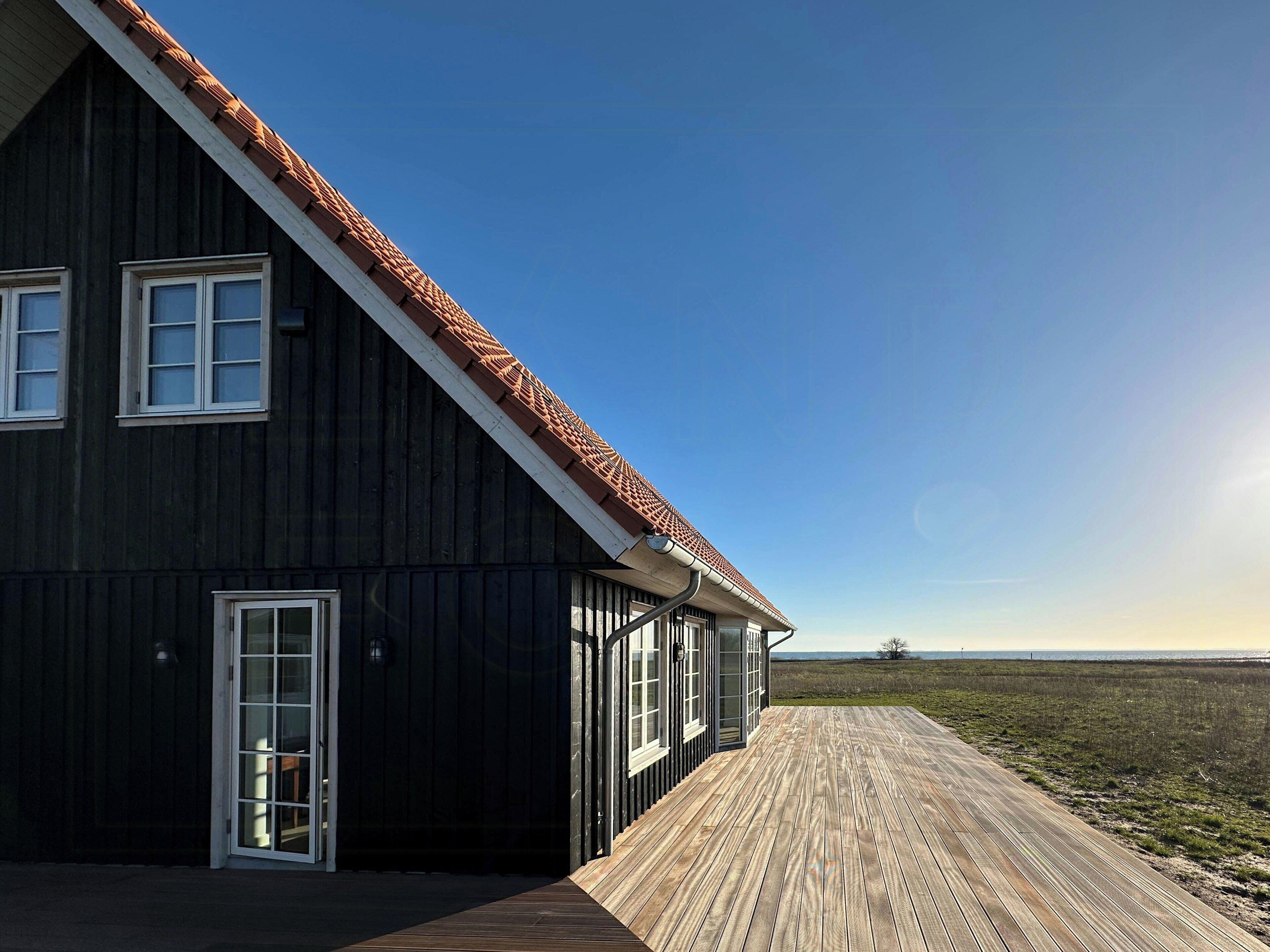 Un grand bâtiment en bois, doté d’un toit en pente et d’une terrasse en bois.