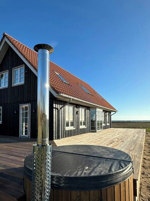 A house with a red-tiled roof, large windows, and a wooden deck. - House with great sea view on Lilleø (Lilleø)