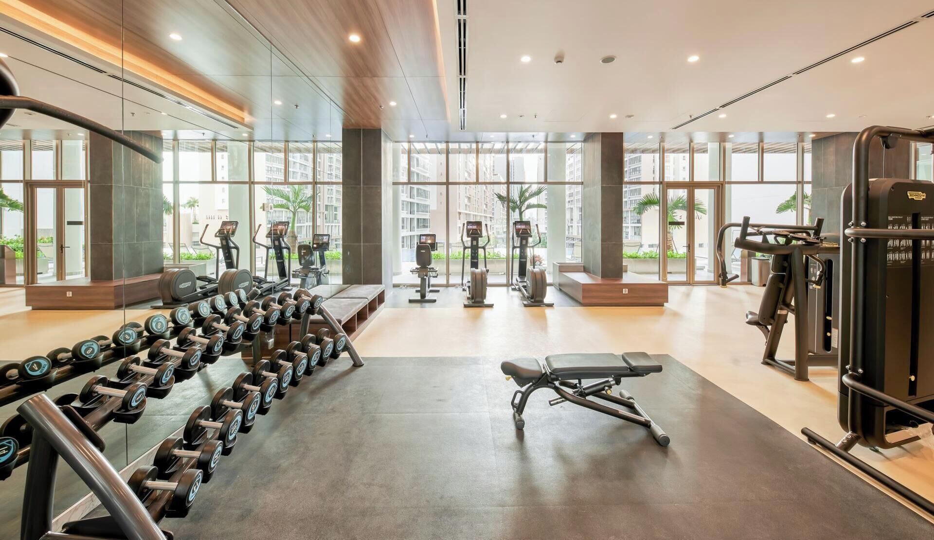 Ein modernes Fitnessstudio mit Trainingsgeräten, großen Fenstern und einem sauberen, großzügigen Innenraum.
