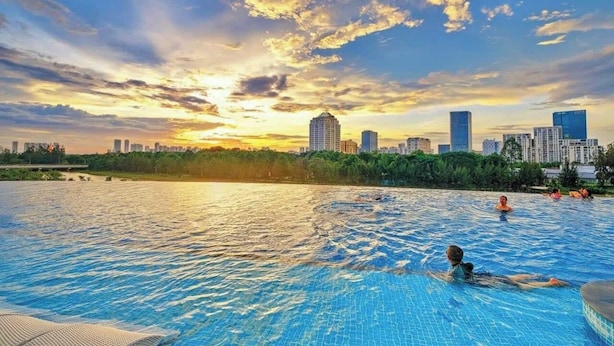 Ein Schwimmbecken mit Stadtansicht im Hintergrund.