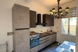 Eine moderne Küche mit Einbauofen, Spüle und Essbereich inklusive Tisch und Stühlen.