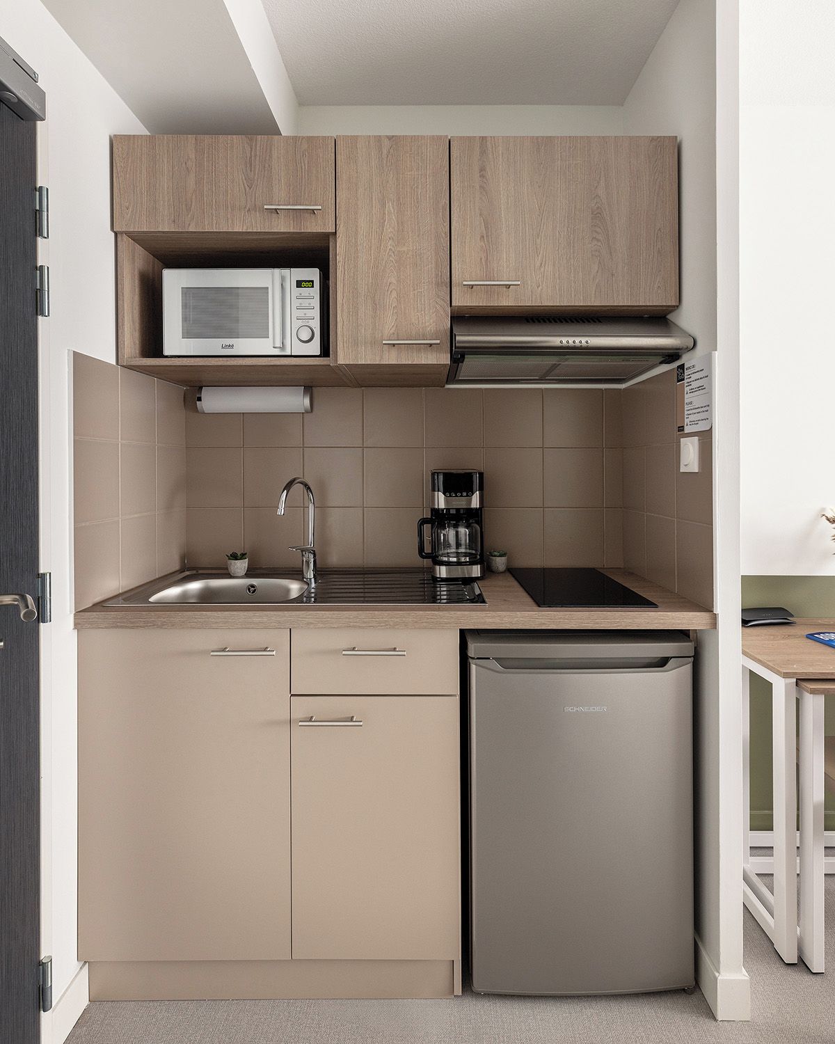 A compact kitchen with a microwave, coffee maker, and dishwasher.