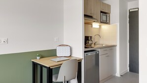 A compact kitchen with a microwave, coffee maker, and dishwasher.