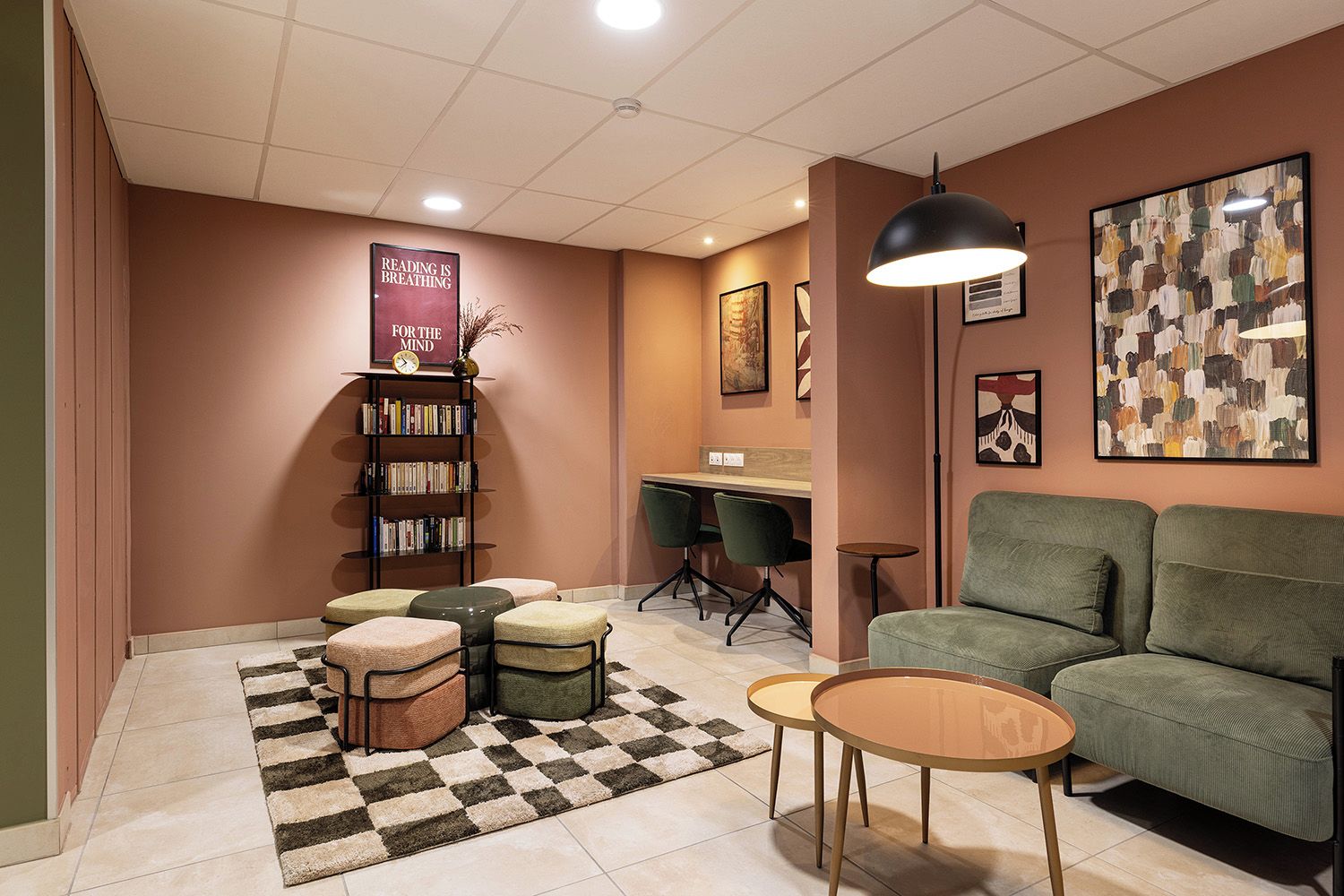 A cozy reading area with a bookshelf, a desk, and a sofa.