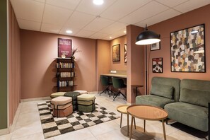 Ein gemütlicher Leseplatz mit Bücherregal, Schreibtisch und Sofa.