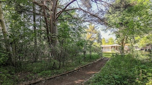 A forested path leading to a building with a large window and a door. - Cottage with forest idyll and peace by Arresø (Frederiksværk)