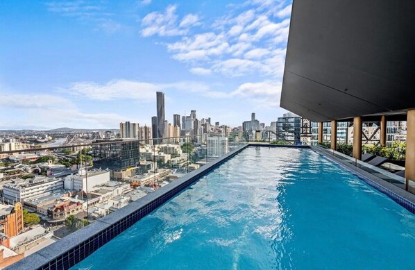 A rooftop infinity pool with a city skyline view. - Stunning 2 Bedroom Retreat with Rooftop Pool! (Fortitude Valley)