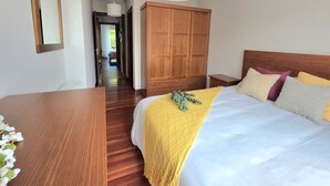 Une chambre à coucher avec un lit, une armoire en bois et un couloir.