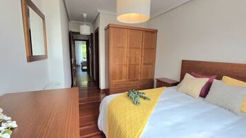 2 dormitorios, tabla de planchar con plancha, ropa de cama