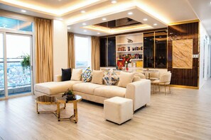 A modern living room with a sofa, coffee table, and a bookshelf. - The Crown Luxury 4BR Penthouse (Phu Nhuan)