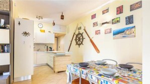 Una cucina con zona pranzo, un orologio, una ruota di timone e diverse decorazioni a parete.