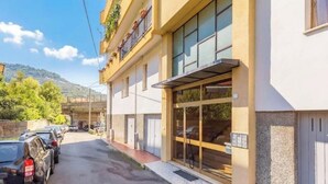 Un edificio con una facciata moderna, ampie finestre e un'area di parcheggio con auto.