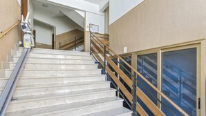 Una scala con ringhiera in legno e balaustre in metallo, che conduce a un piano superiore.