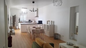 Eine moderne Küche mit Essbereich, weißen Wänden und Holzboden.